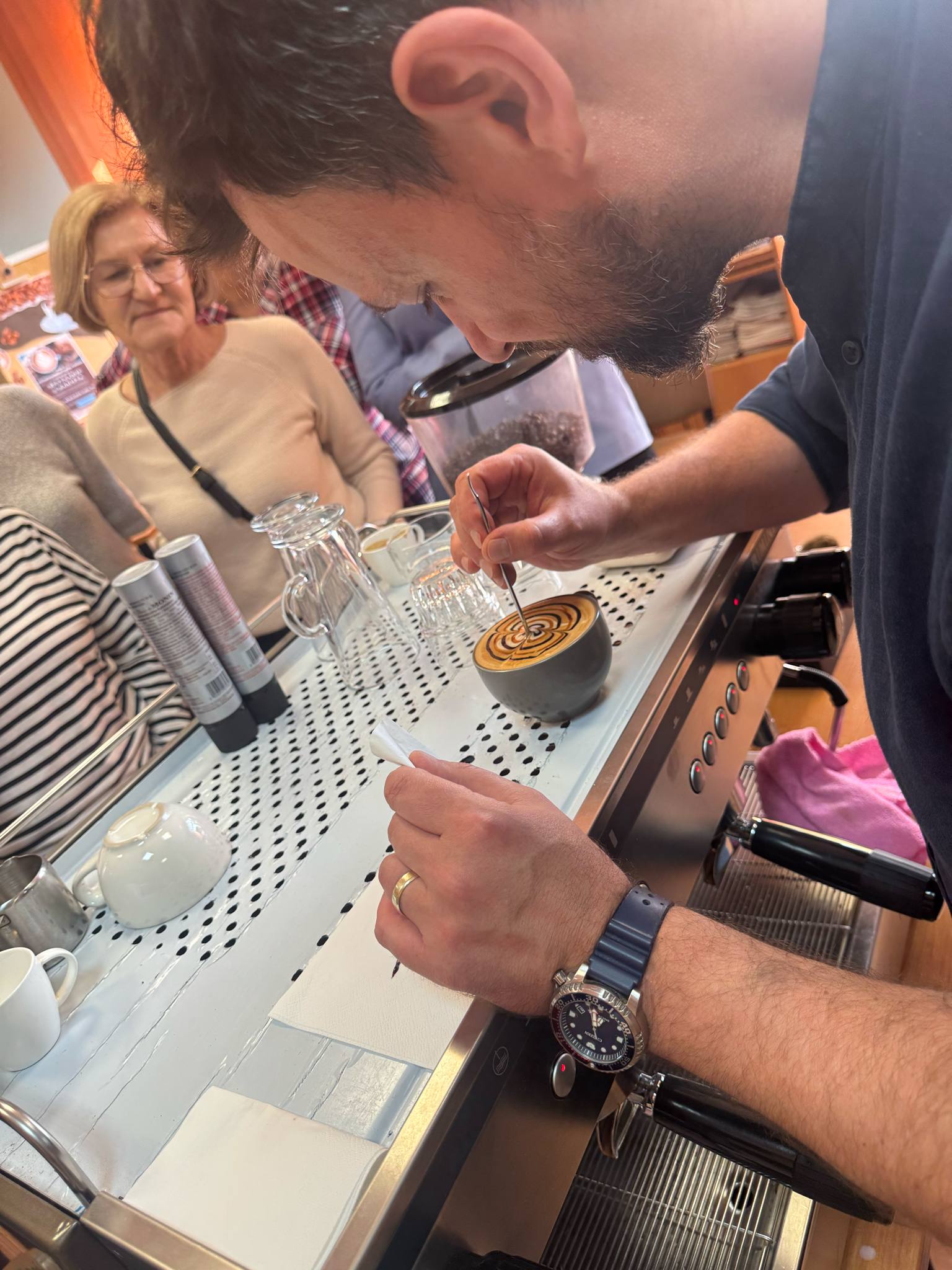 barista maluje wzór na kawie