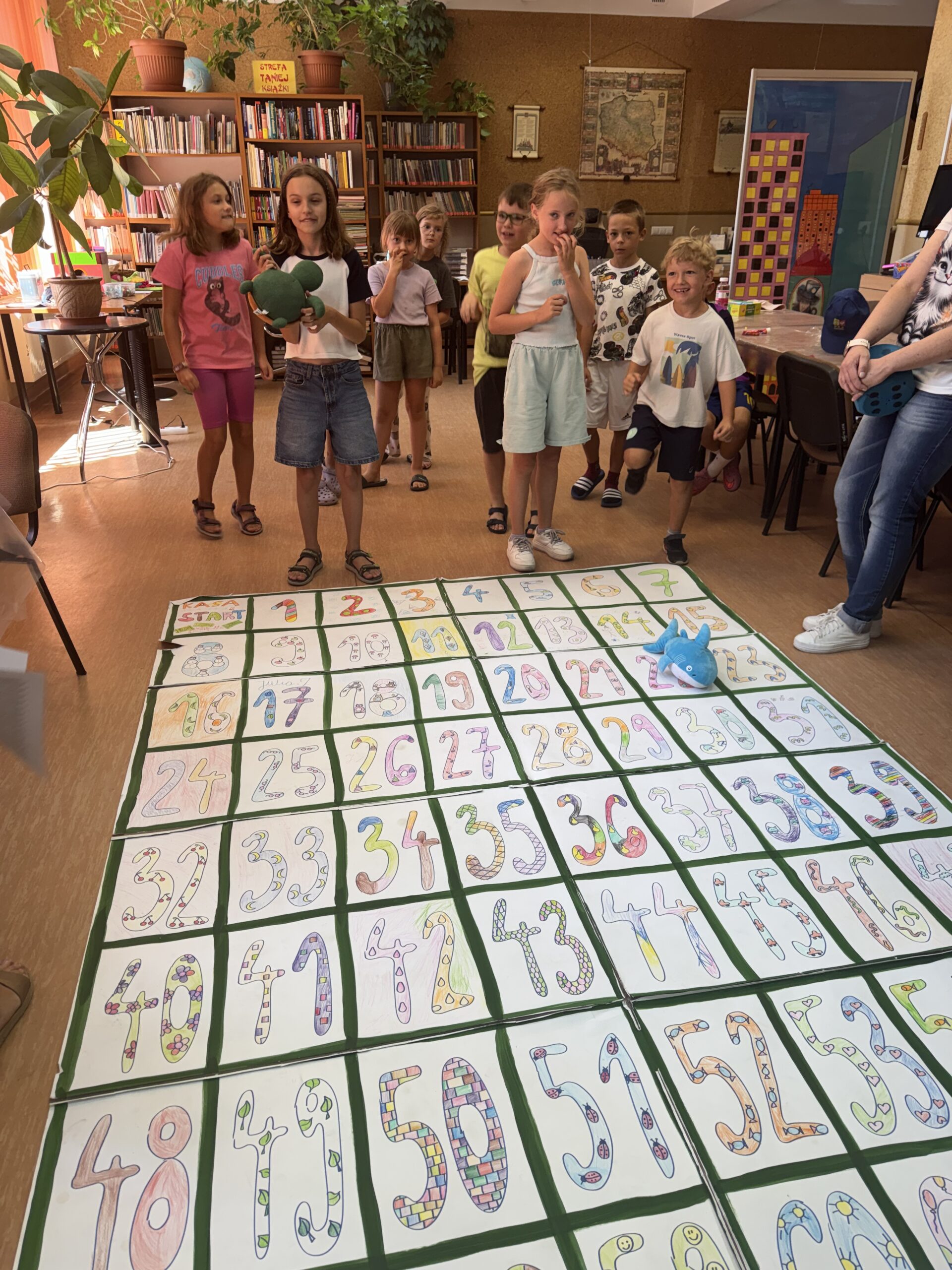 dzieci grają w wielkoformatową grę planszową