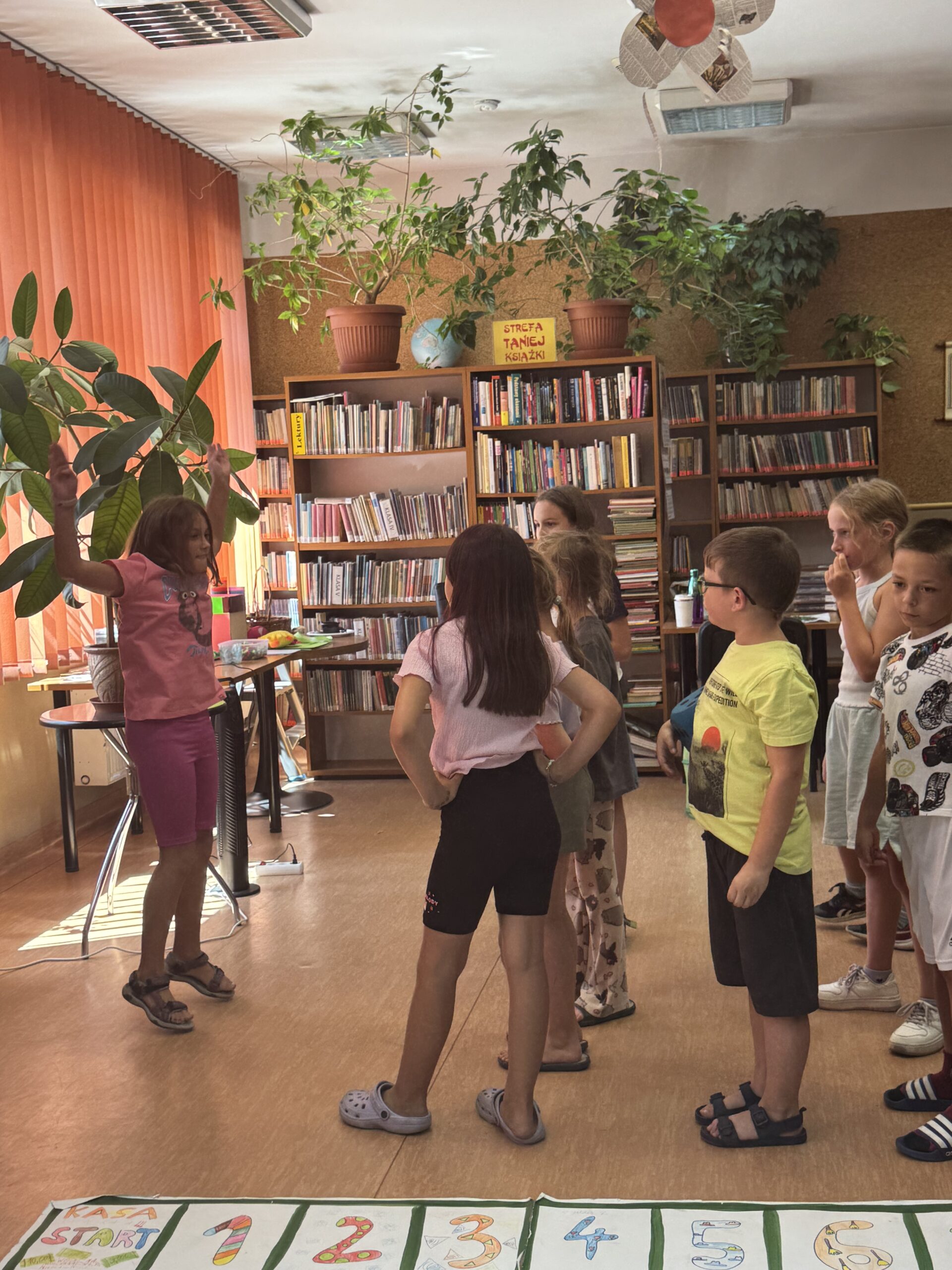 dzieci grają w wielkoformatową grę planszową